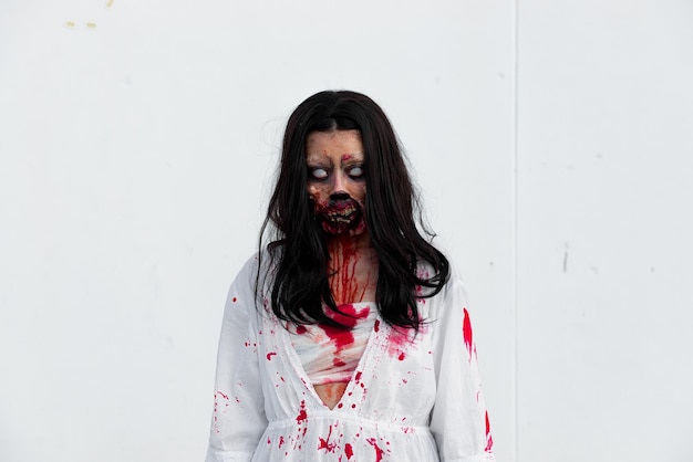 Portret van Aziatische vrouw make-up spookgezicht met bloed op witte achtergrond Horror scene Enge achtergrond Halloween posterThailand mensen