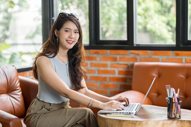 Portret van Aziatische zakenvrouw met een laptop mooie vrouw die stylig aan een computer werkt Werkend Design op een creatieve werkplek