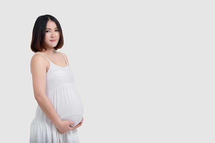 Portret van aziatische zwangere vrouw op witte achtergrond thailand mensen gebruiken handaanraking buik
