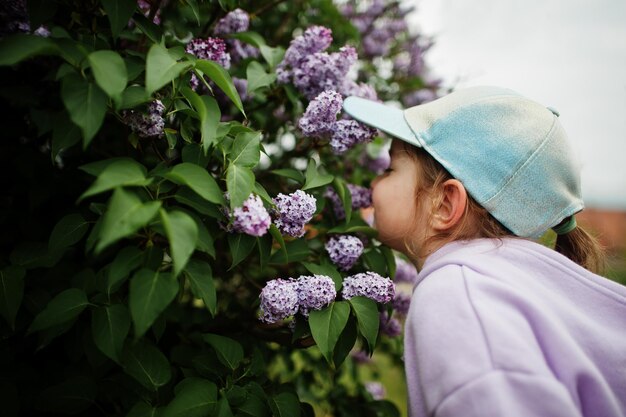 Portret van babymeisje in petstandaard in de buurt van lila boom