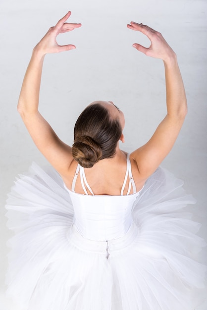 Portret van ballerina in klassieke tutu in de grijze studio.