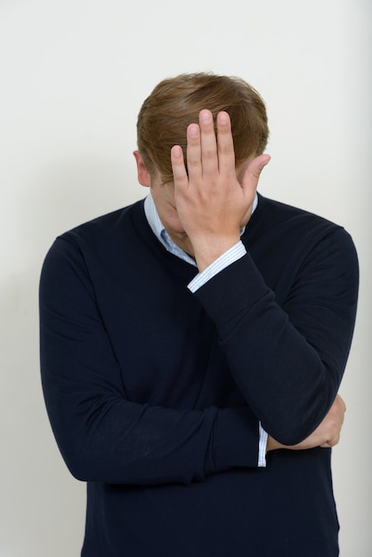 Foto portret van beklemtoonde man met blond haar met hoofdpijn