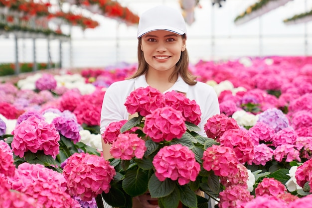 Portret van bloemist poseren onder kleurrijke bloeiende hortensia