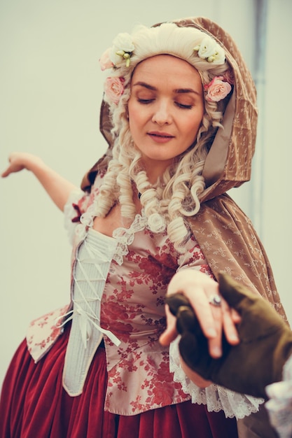 Portret van blonde vrouw gekleed in historische barokke kleding met ouderwets kapsel