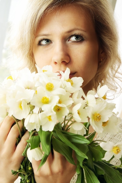 Portret van blonde vrouw met een bos nieskruid