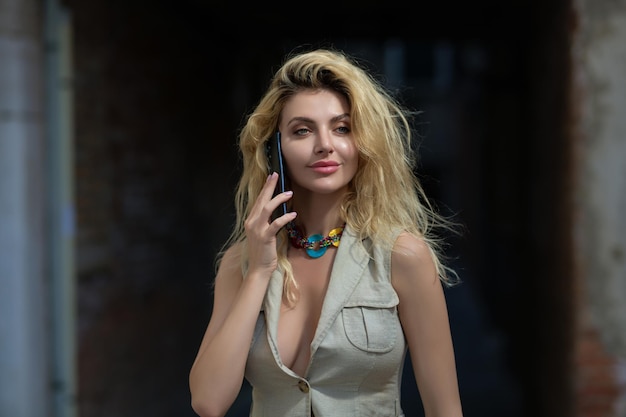 Portret van blonde vrouw met mobiele telefoon mooi meisje praten via mobiele telefoon met behulp van smartphone