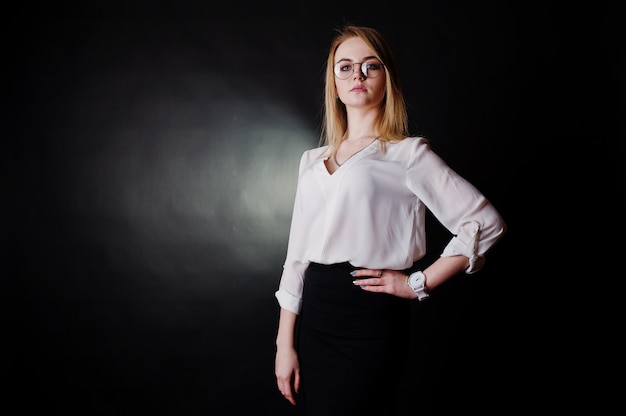 portret van blonde zakenvrouw in glazen, witte blouse en zwarte rok tegen. Succesvolle vrouw en stijlvol meisjesconcept.