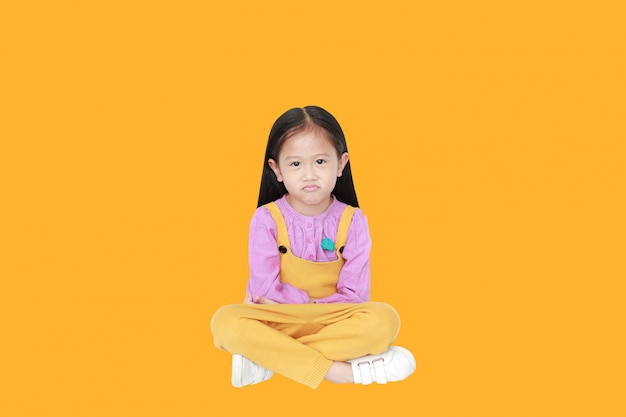 Portret van boos klein aziatisch kindmeisje in roze