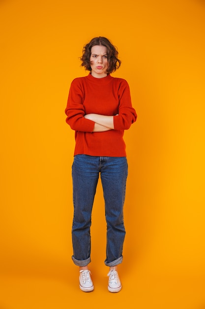 portret van boos ontevreden jonge mooie vrouw poseren geïsoleerd over gele muur.