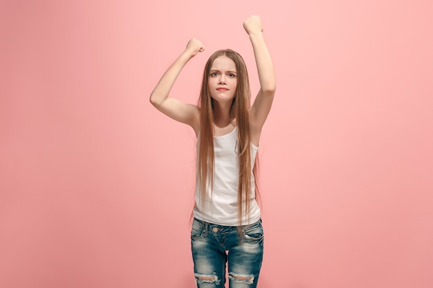 Foto portret van boos tienermeisje op een roze muur