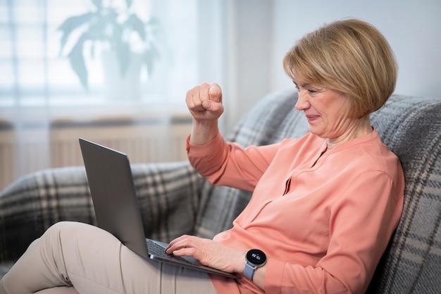 Portret van boze woedende vrouwenhater, senior agressieve dame met laptopcomputer en schreeuw