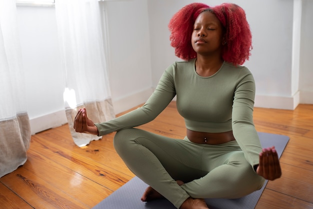 Foto portret van braless vrouw die yoga thuis doet