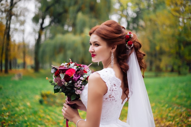 Portret van bruid met een boeket bloemen in het park, alle zonnige dag