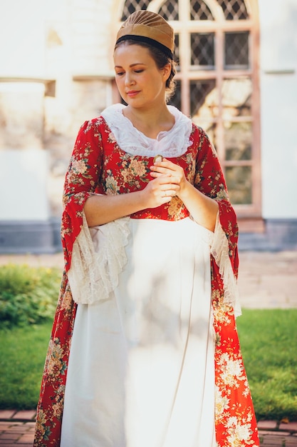 Portret van brunette vrouw gekleed in rode historische barokke kleding
