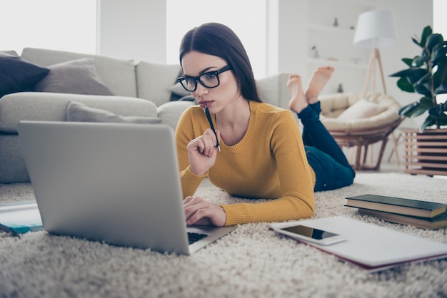 portret van brunette vrouw op de vloer met laptop