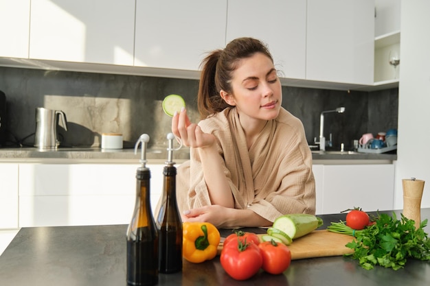 Portret van brunette vrouw vrouw koken thuis maken van diner poseren in de buurt van snijplank in de keuken