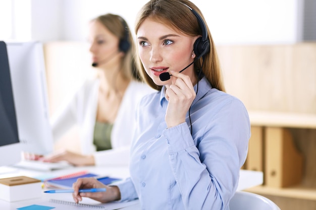 Portret van callcenteroperator op het werk. groep mensen in een headset klaar om klanten te helpen. bedrijfsconcept.