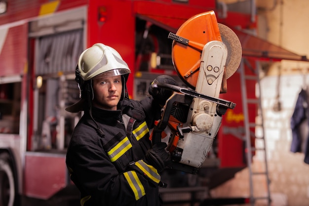 Foto portret van de brandweerman die de uitrusting vasthoudt