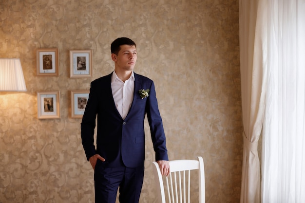 portret van de bruidegom in een hotelkamer