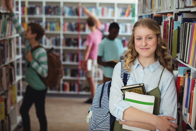 Portret van de gelukkige boeken van de schoolmeisjeholding in bibliotheek