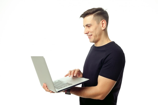 Portret van de glimlachende jonge geïsoleerde mens met laptop