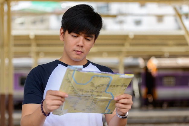 Portret van de jonge knappe Filipijnse toeristenmens bij het treinstation van Hua Lamphong in Bangkok