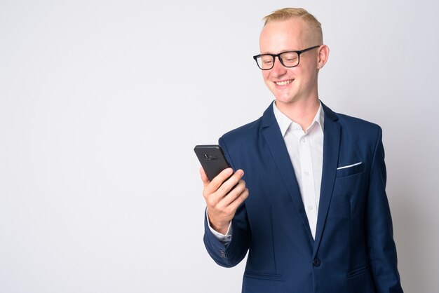 portret van de jonge knappe zakenman met kort blond haar in pak en bril op wit