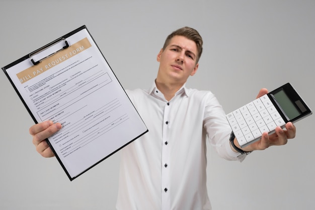 Portret van de jonge mens met vorm van betaling van rekeningen en calculator in zijn handen op wit