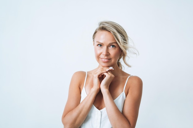 Portret van de jonge vrouw van het blondehaar die op witte achtergrond wordt geïsoleerd