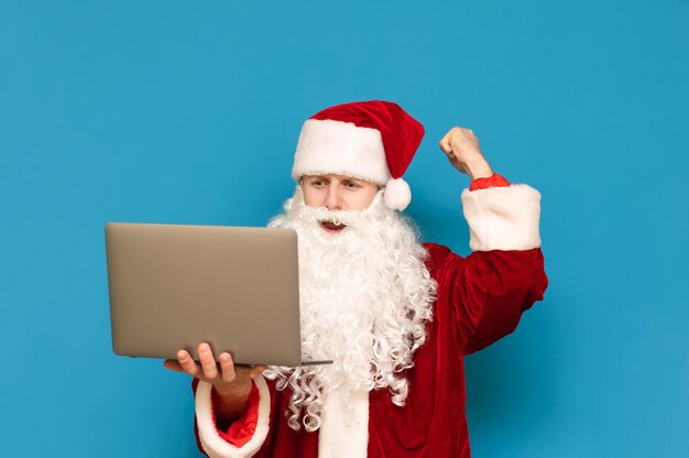 Portret van de kerstman met laptop