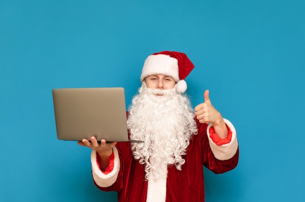 Portret van de kerstman met laptop