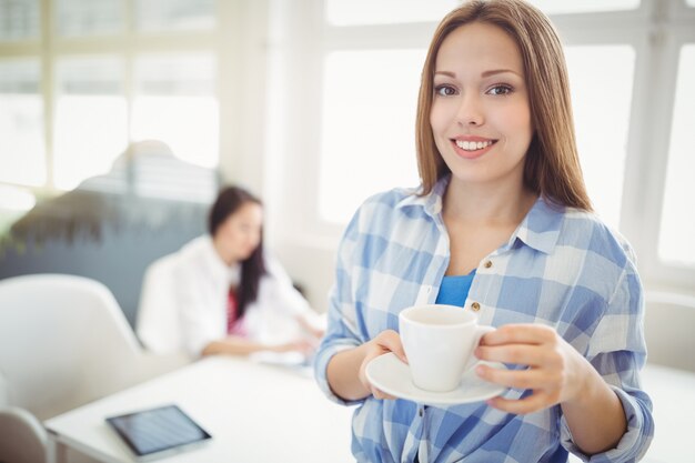 Portret van de koffiekop van de onderneemsterholding op creatief kantoor