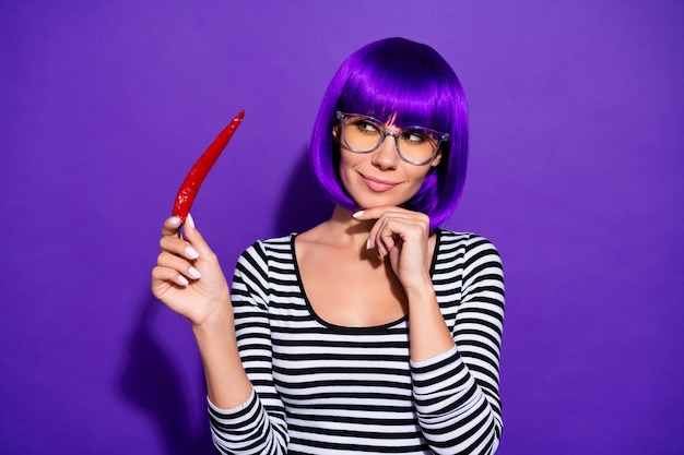 Portret van de mooie peper die van de persoonsholding met gedachten kijkt gekleed gestreept overhemd dat over purpere violette achtergrond wordt geïsoleerd