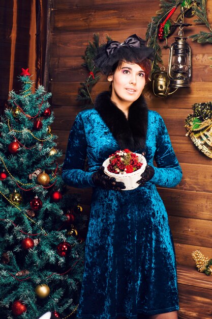 Portret van de mooie vrouw in de buurt van de kerstboom.