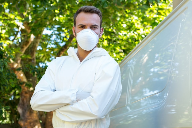 Portret van de ongediertebestrijdingsmens die zich naast een bestelwagen bevindt