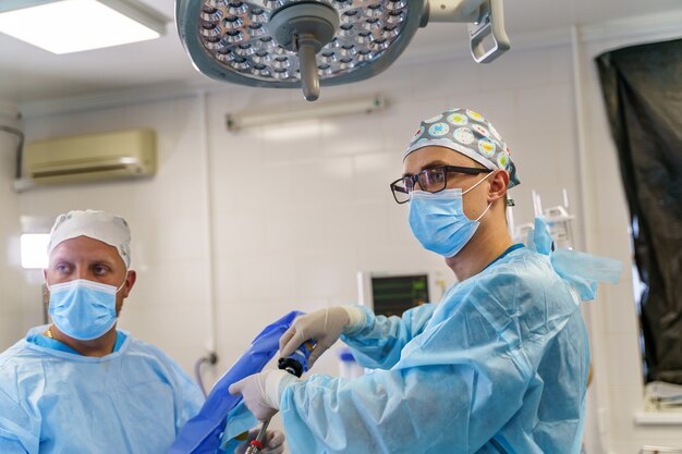 Portret van de professionele medici met chirurgische maskers tijdens de operatie. Moderne ziekenhuis operatiekamer.