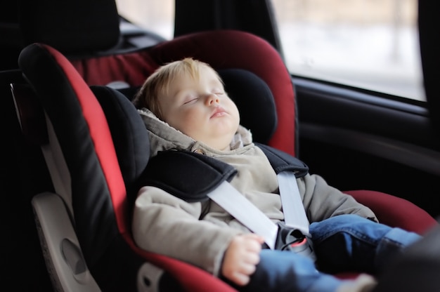 Portret van de slaap van de peuterjongen in autozetel
