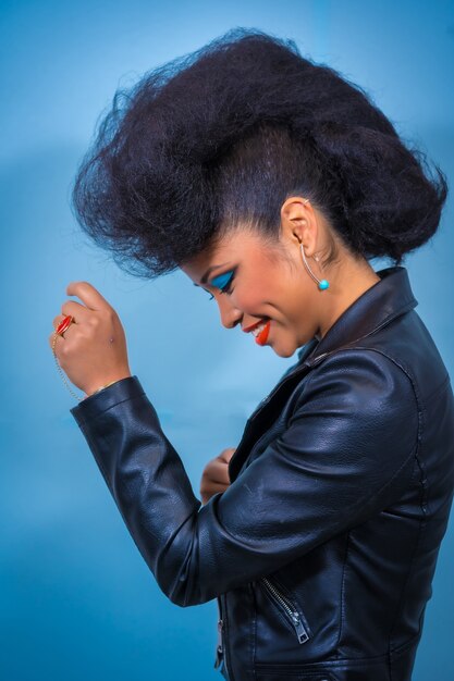 Portret van de stijlvrouw van de maniertuimelschakelaar met lichte make-up die een leerjasje draagt