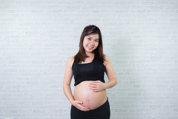 Portret van de zwangere vrouwen van Azië op witte achtergrond