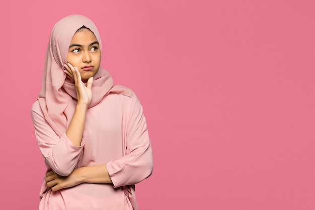 Foto portret van denken jonge aziatische vrouw opzoeken en kin aanraken