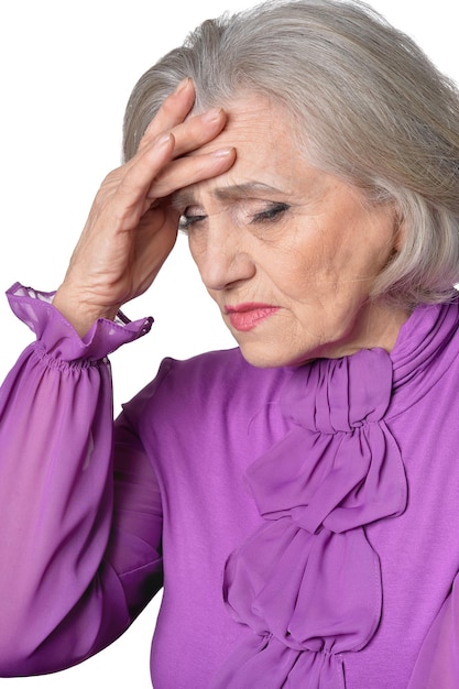 Portret van doordachte senior vrouw met hoofdpijn geïsoleerd op een witte achtergrond