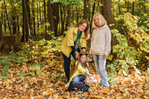 Portret van drie generaties gelukkige mooie vrouw en hond in de herfstnatuur