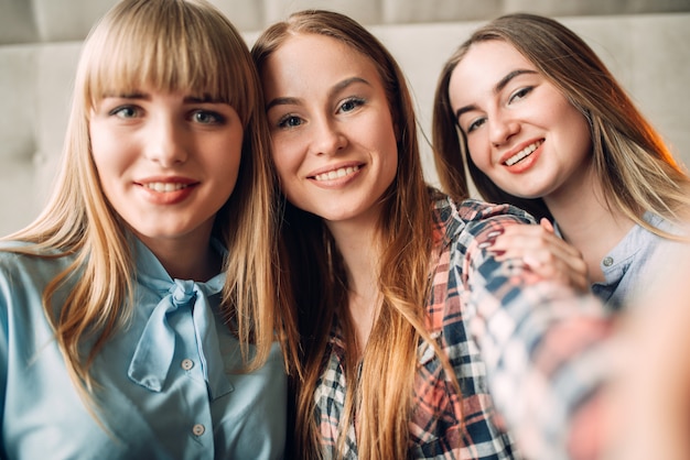 Portret van drie jonge lachende vriendinnen. Vriendinnen zitten in restaurant en plezier, roddelaars bijeen