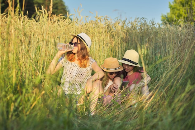 Portret van drie meisjes die en in gras zitten rusten