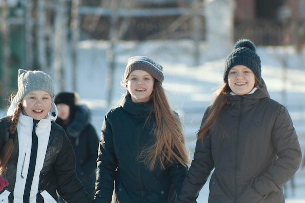 Portret van drie tienermeisjes die winterkleren dragen in de winter buiten