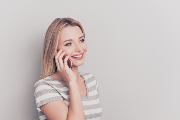 Portret van een aantrekkelijke blonde vrouw die smartphone gebruikt