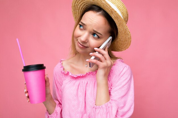 Portret van een aantrekkelijke, emotionele jonge blonde vrouw met een stijlvolle roze blouse en trendy