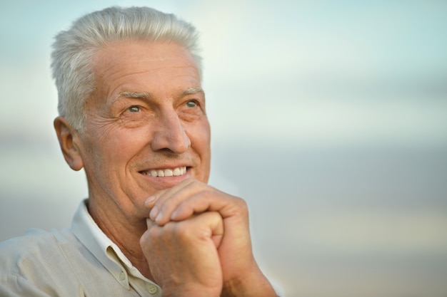 Portret van een aantrekkelijke oudere man op de achtergrond van de lucht