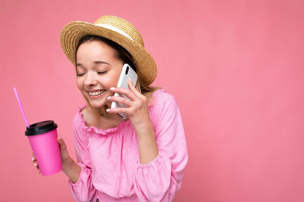 Portret van een aantrekkelijke positieve emotionele jonge blonde vrouw met een stijlvolle roze blouse en trendy