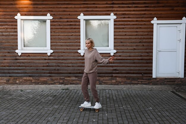 Portret van een aantrekkelijke vrolijke vrouw die leert skaten om te skateboarden en een weekend in de frisse lucht buiten doorbrengt